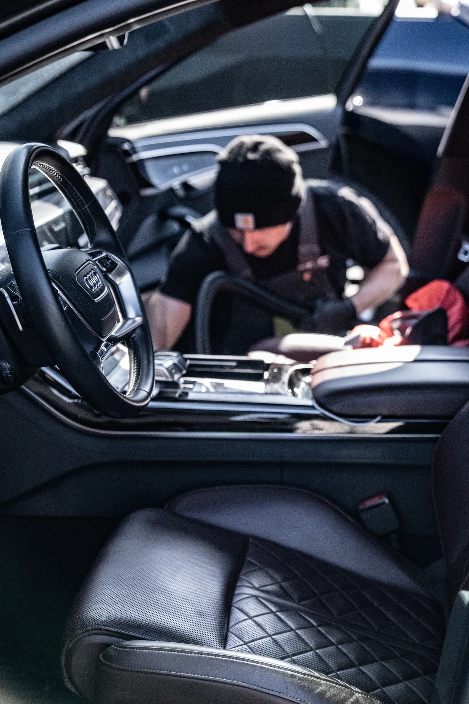Detailer cleaning the centre console of an Audi interior